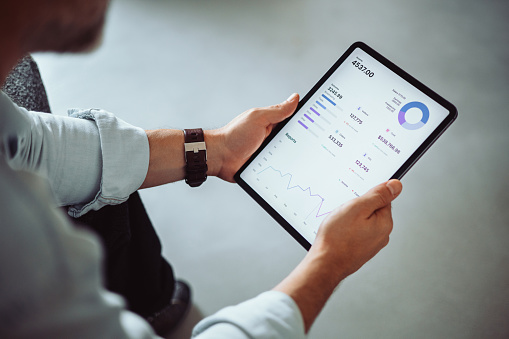 Person analyzing financial data on a digital tablet